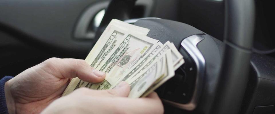 Man counting dollar bills sitting in a car, Close up of male hands count money cash. Concept of earnings or bribes, insurance or credit, investing