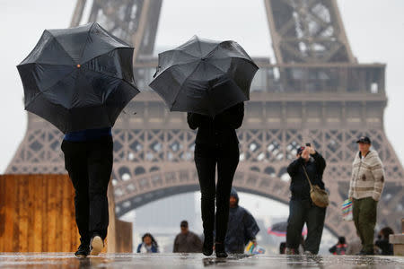 Tourists stroll on the Trocadero square, in front of the Eiffel Tower during a rainy day in Paris, France, May 30, 2016. REUTERS/Charles Platiau