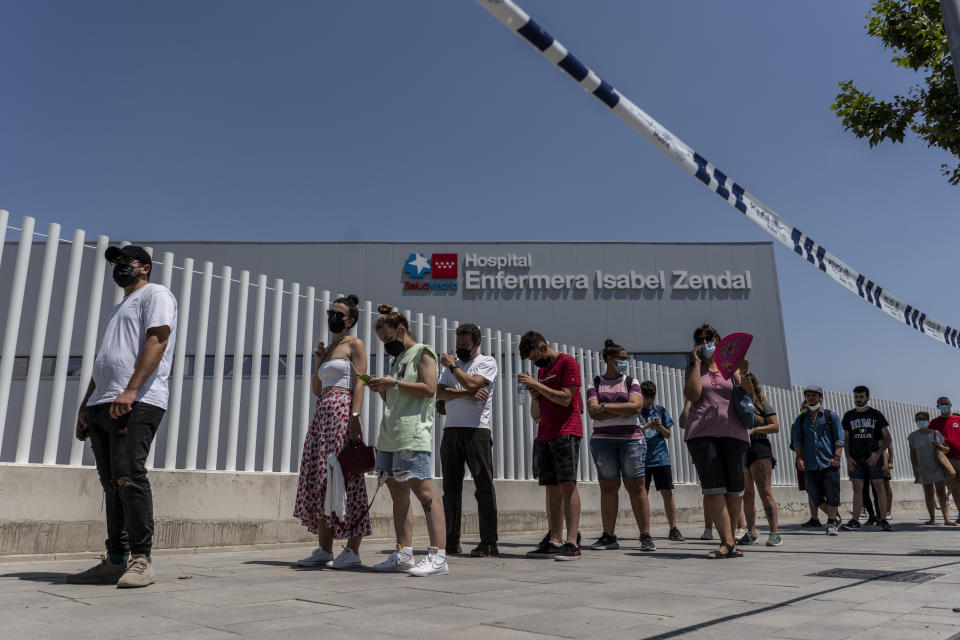 People queue to be vaccinated against COVID-19 at the Isabel Zendal Hospital in Madrid, Spain, Tuesday, July 20, 2021. Spain is trying to stamp out a new wave of COVID-19 among its youth thanks to a robust vaccination program that is widely supported. Spain like the rest of the European Union got off to a slow start to compared to the United States and Britain when the first vaccines were released. But it has quickly made up ground once deliveries by drug makers started flowing. (AP Photo/Olmo Calvo)