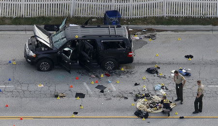 Law enforcement officers look over the evidence near the remains of a SUV involved in a shooting attack in San Bernardino, California December 3, 2015. REUTERS/Mario Anzuoni