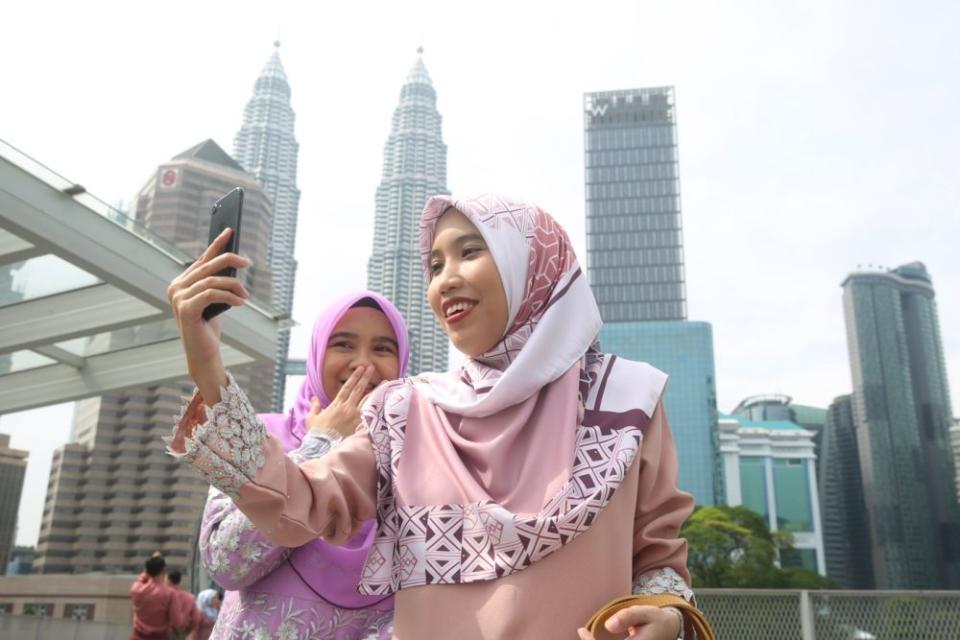 Members of the public pose for pictures at the Saloma Link Bridge in Kuala Lumpur on the first day of Syawal May 24, 2020. — Picture by Choo Choy May