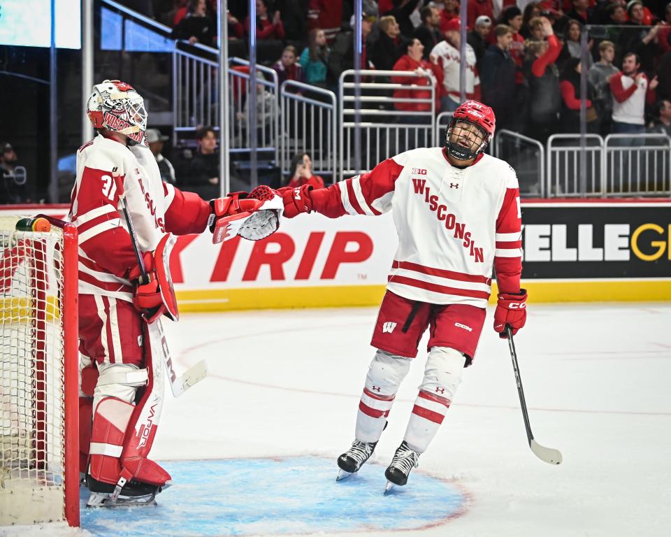Wisconsin forward Simon Tassy (11) and goaltender Kyle McClellan (31) exchange congratulations after Tassy scored against Northeastern during the third period of the championship game of the Kwik Trip Holiday Face-Off on Friday, December 29, 2023, at Fiserv Forum in Milwaukee, Wisconsin. Wisconsin won, 3-0.