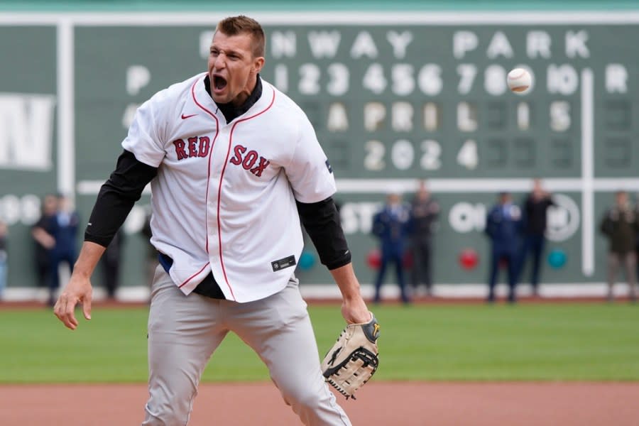 Former New England Patriots NFL football player Rob Gronkowski reacts after spiking the ball instead of throwing it during the ceremonial first pitch before a baseball game between the Boston Red Sox and the Cleveland Guardians, Monday, April 15, 2024, in Boston. (AP Photo/Michael Dwyer)