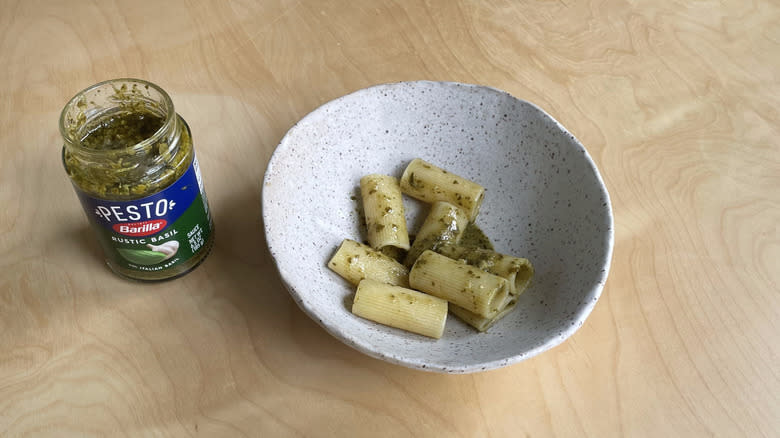 pesto jar next to pasta bowl 