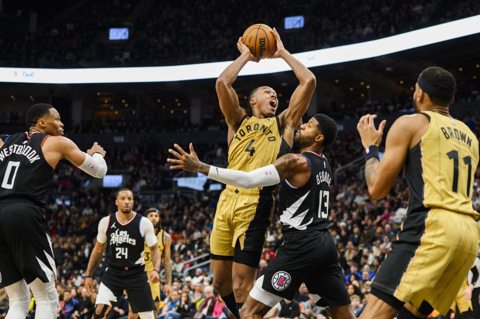 Toronto Raptors forward Scottie Barnes (4) goes to the basket while guarded by Los Angeles Clippers forward Paul George (13) during the second half of an NBA basketball game in Toronto, Friday, Jan. 26, 2024. (Christopher Katsarov/The Canadian Press via AP)