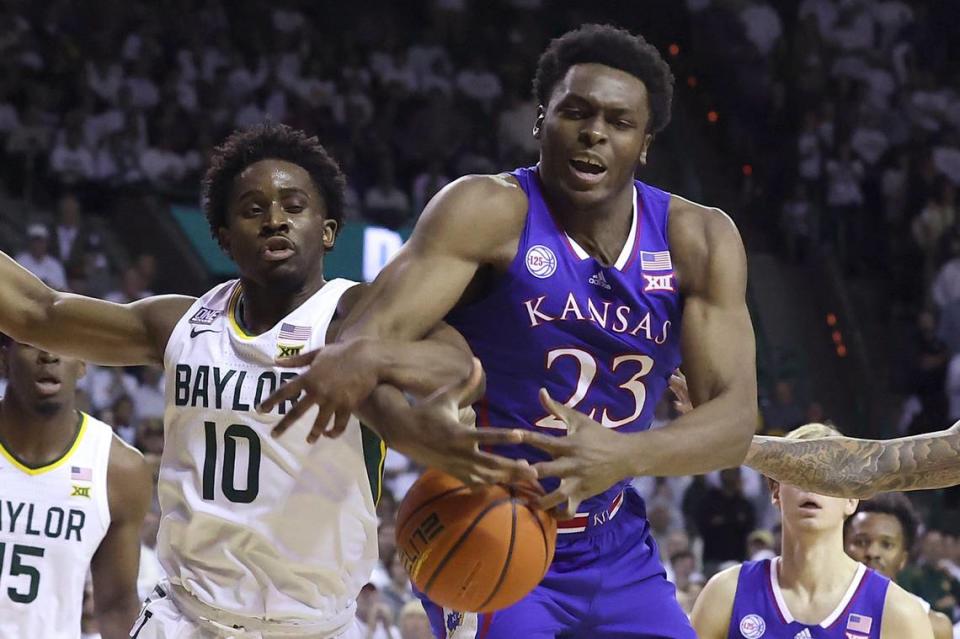 Kansas center Ernest Udeh Jr. (23) and Baylor guard Adam Flagler (10) get tied up while trying to retrieve the ball during the first half of an NCAA college basketball game Monday, Jan. 23, 2023, in Waco, Texas. (AP Photo/Jerry Larson)