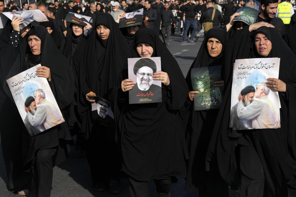 Mourners attend a funeral ceremony for the late Iranian President Ebrahim Raisi, shown in the posters, and his companions who were killed in a helicopter crash on Sunday in a mountainous region of the country's northwest, in Tehran, Iran, Wednesday, May 22, 2024. Iran's supreme leader presided over the funeral Wednesday for the country's late president, foreign minister and others killed in the helicopter crash, as tens of thousands later followed a procession of their caskets through the capital, Tehran. (AP Photo/Vahid Salemi)