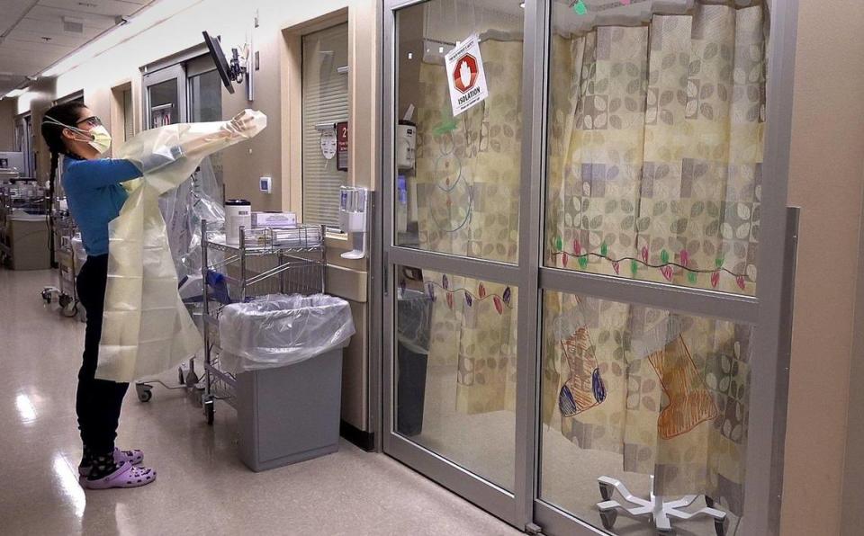 Delaney Swanson, a registered nurse in the COVID intensive care unit at University Health in Kansas City, enters a patient’s room for a visit. Like other hospitals, most of the patients there are unvaccinated.