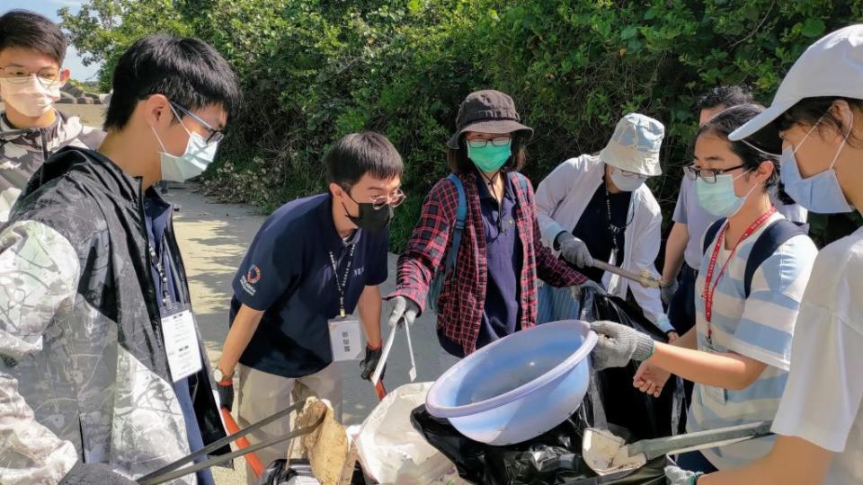 高雄大學攜手新莊高中師生清除濕地、沙灘垃圾，保護陸蟹棲地。（記者王正平翻攝）