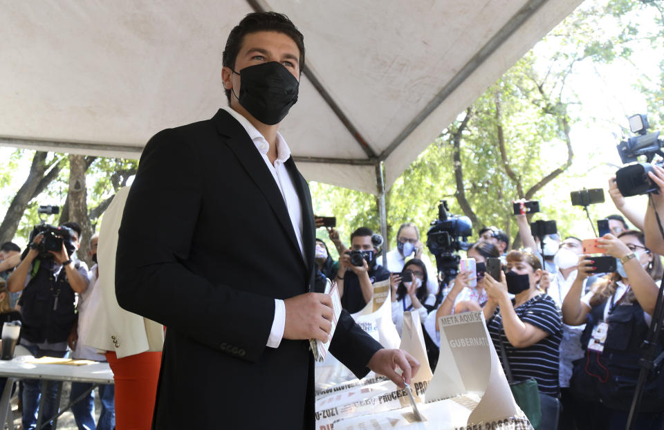Samuel Garcia casts his ballot during mid-term elections in Monterrey, Nuevo Leon state, Mexico, Sunday, June 6, 2021. Garcia, 33, is a baby-faced former senator whose blond wife, YouTuber Mariana Rodríguez, is better known for posting videos of herself giving makeup tutorials or clutching a small dog. (AP Photo/Roberto Martinez)