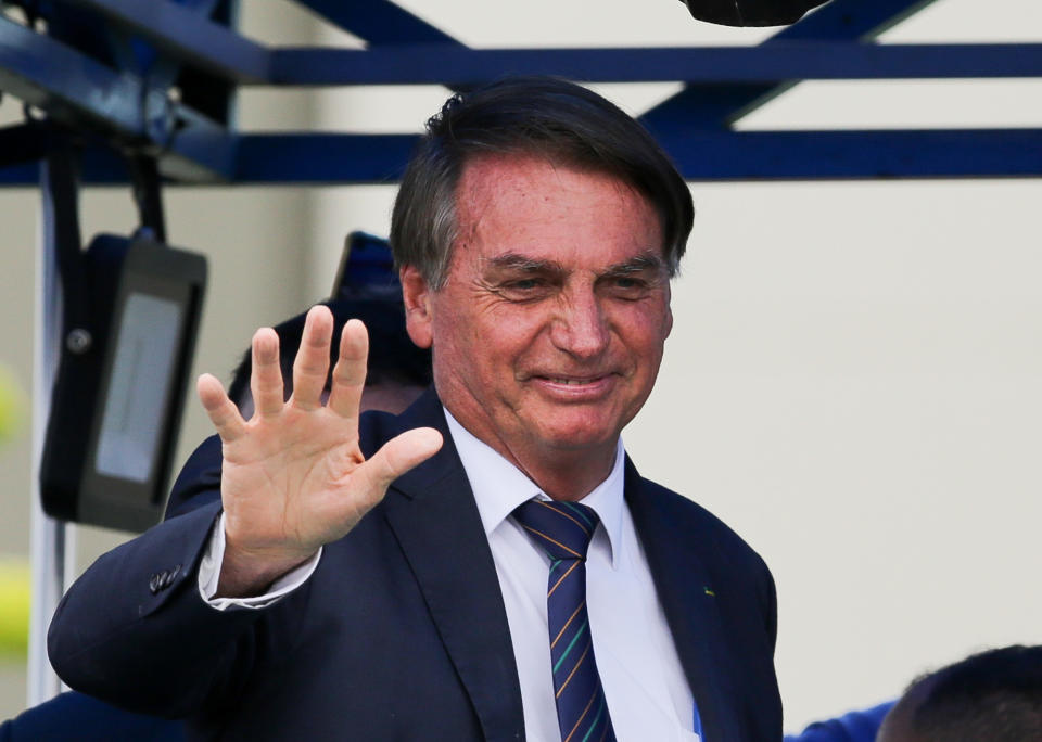 Brazilian President Jair Bolsonaro waves to supporters outside a convention center in Brasilia, Brazil, Tuesday, Nov. 30, 2021, after attending a ceremony where he officially joined the centrist Liberal Party. (AP Photo/Raul Spinasse)