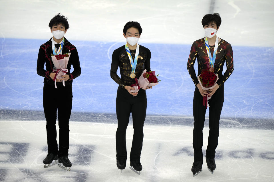 From left, men's singles silver medalist Shun Sato of Japan, gold medalist Yuma Kagiyama of Japan, and bronze medalist Jin Boyang of China pose on the ice during their medal ceremony at the Asian Open Figure Skating Trophy, a test event for the 2022 Winter Olympics, at the Capital Indoor Stadium in Beijing, Friday, Oct. 15, 2021. (AP Photo/Mark Schiefelbein)