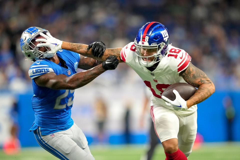 DETROIT, MICHIGAN - AUGUST 11: Isaiah Hodgins #18 of the New York Giants stiff arms Will Harris #25 of the Detroit Lions during the first quarter of the preseason game at Ford Field on August 11, 2023 in Detroit, Michigan. (Photo by Nic Antaya/Getty Images)