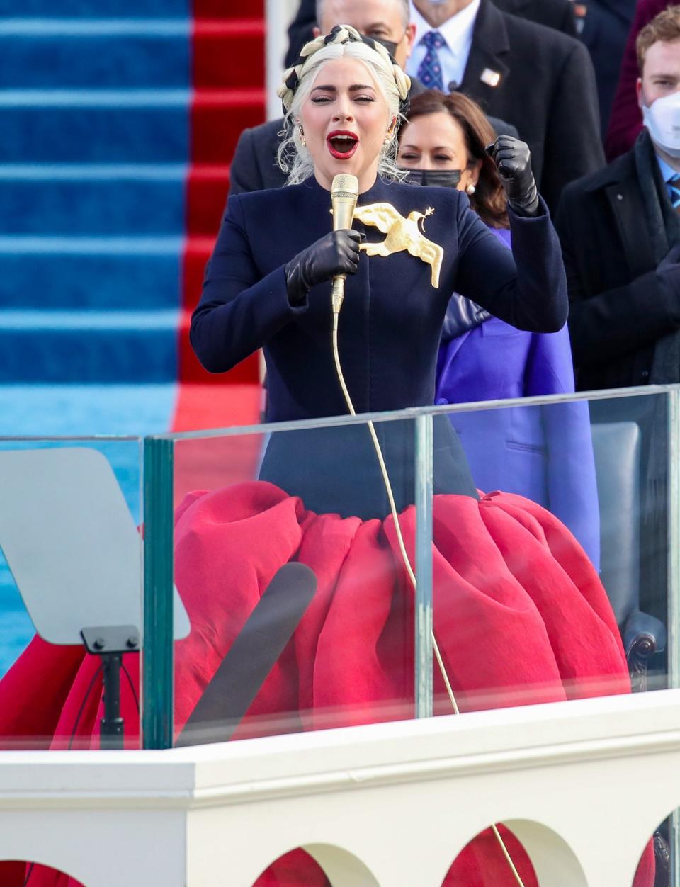 <p>There to perform the national anthem, Lady Gaga was beaming as she arrived at the Capitol. The singer sang beautifully while Twitter began to light up with comments about her <a href="https://people.com/tag/the-hunger-games/" rel="nofollow noopener" target="_blank" data-ylk="slk:Hunger Games;elm:context_link;itc:0;sec:content-canvas" class="link "><em>Hunger Games</em></a>-esque look. Her large accessory was <a href="https://twitter.com/ladygaga/status/1351952799911669762" rel="nofollow noopener" target="_blank" data-ylk="slk:a peace dove;elm:context_link;itc:0;sec:content-canvas" class="link ">a peace dove</a> carrying an olive branch, her nod to a hopeful future under the Biden administration. </p>