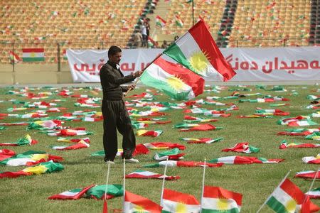 A man carries the Kurdistan flags before the start of a rally calling to vote yes in the coming referendum, in Erbil, Iraq September 22, 2017. REUTERS/Azad Lashkari/Files