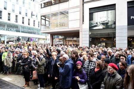 People observe a minute of silence at the crash site at Ahlens department store to remember the victims of Friday's attack on Drottninggatan, Stockholm, Monday, April 10, 2017. TT NEWS AGENCY/Christine Olsson via REUTERS