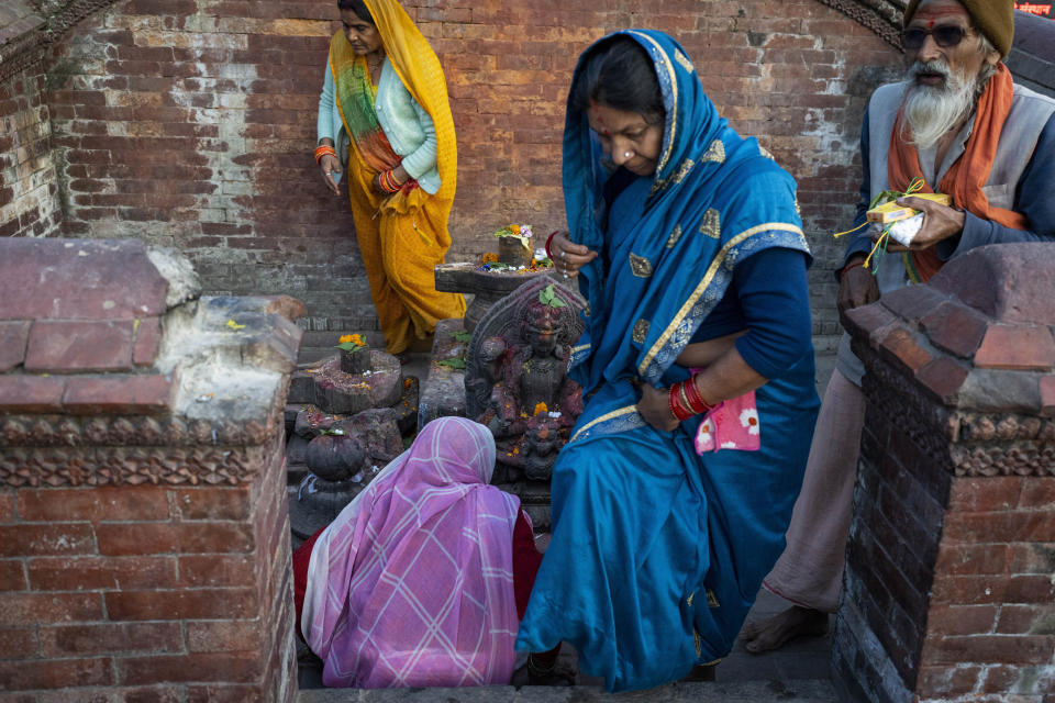 Indian pilgrims offer prayers to "Shivalinga," a block of stone symbolizing the powerful Hindu god Shiva at Pashupatinath temple premises in Kathmandu, Nepal, Jan. 9, 2024. The centuries-old temple is one of the most important pilgrimage sites in Asia for Hindus. (AP Photo/Niranjan Shrestha)