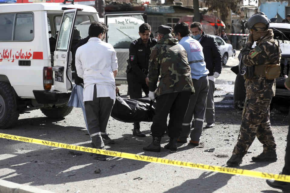 Security personnel and health workers carry a body after a deadly bomb attack in Kabul, Afghanistan, Wednesday, Feb. 10, 2021. (AP Photo/Rahmat Gul)