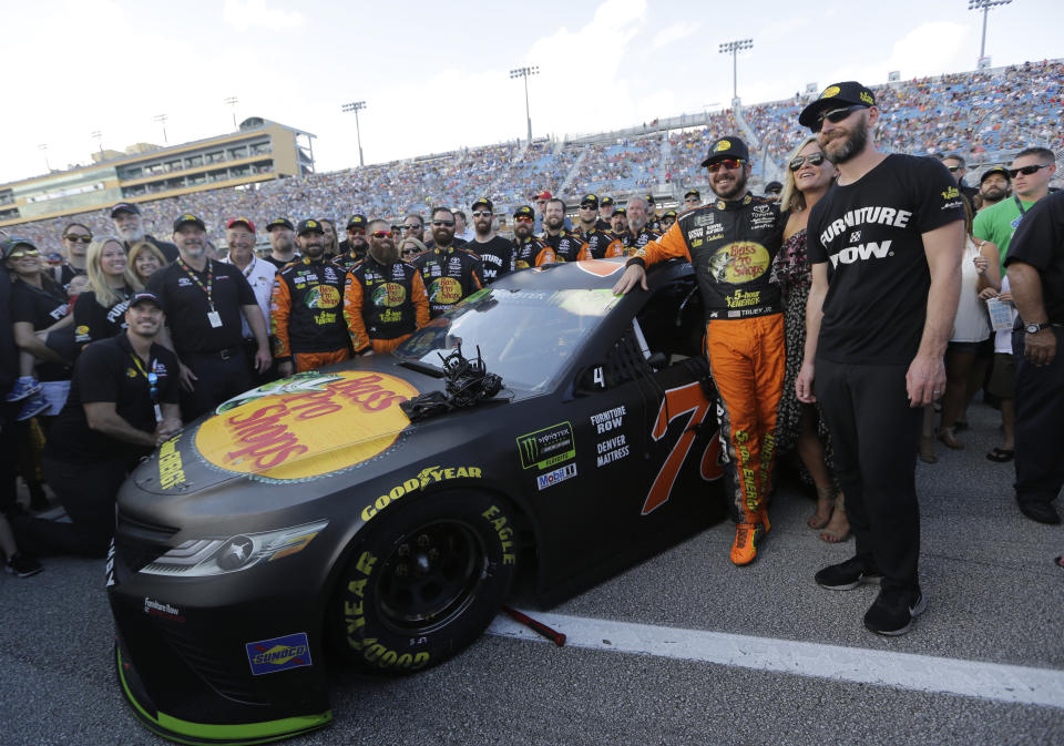 Martin Truex Jr., third from right, poses for a photo with his crew before a NASCAR Series Championship auto race at Homestead-Miami Speedway, Sunday, Nov. 18, 2018, in Homestead, Fla. (AP Photo/Lynne Sladky)