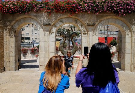 A visitor has her photograph taken at the entrance to an archaeological site known as the City of David, still an active dig and also a tourist attraction, situated close to Silwan, a Palestinian neighbourhood near Jerusalem's Old City June 30, 2016. REUTERS/Ammar Awad