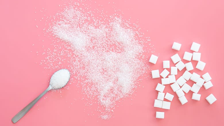 Sugar and cubes scattered on pink surface