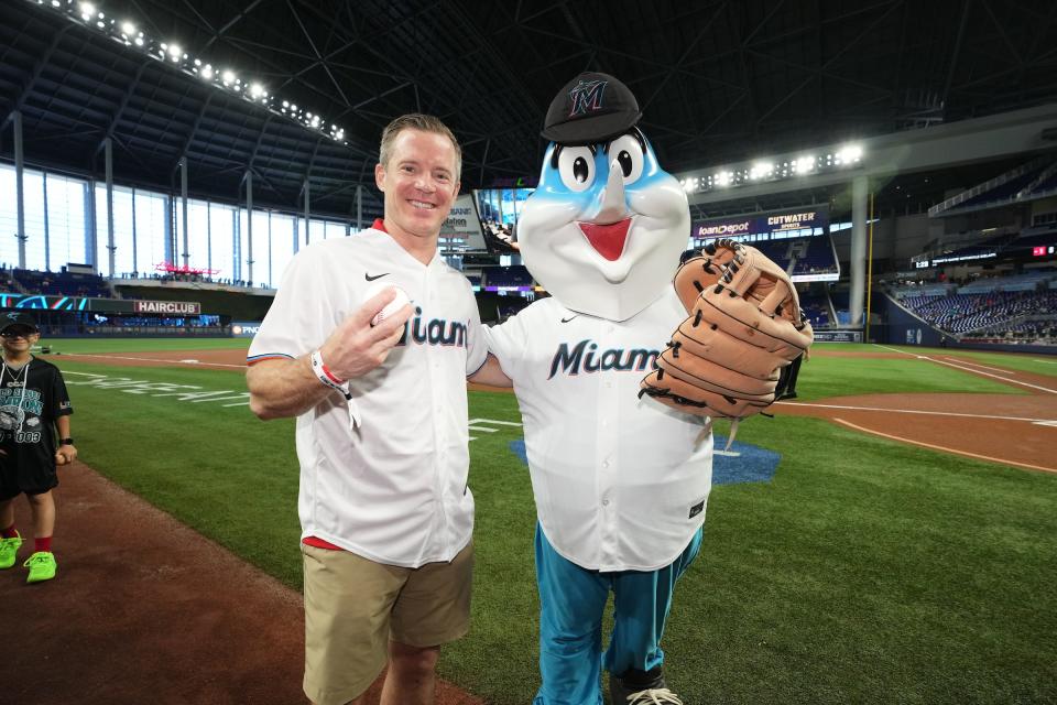 Dusty May poses with the Marlins mascot before throwing out the first pitch at loanDepot park on April 16