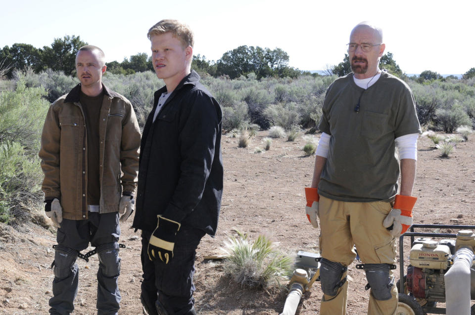 Jesse, Walter, and Todd from Breaking Bad stand at a desert construction site