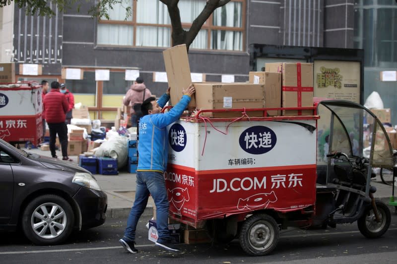 FILE PHOTO: A deliveryman packs parcels on the top of a tricycle after the 11.11 Singles' Day shopping festival in Beijing