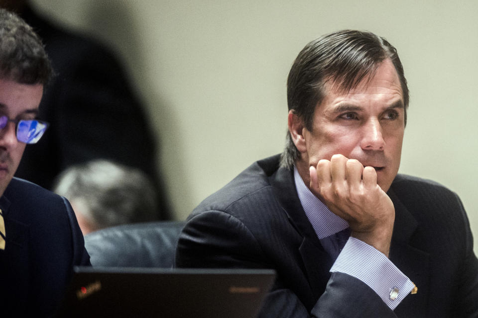 Nick Lyon, director of the Michigan Department of Health and Human Services, listens closely as Genesee District Judge David J. Goggins gives his decision during Lyon's preliminary examination on Monday, Aug. 20, 2018 at Genesee District Court inin Flint, Mich. Goggins ordered Lyons to stand trial for involuntary manslaughter in two deaths linked to Legionnaires' disease in the Flint area, the highest ranking official to stand trial as a result of the tainted water scandal. (Jake May/The Flint Journal via AP)