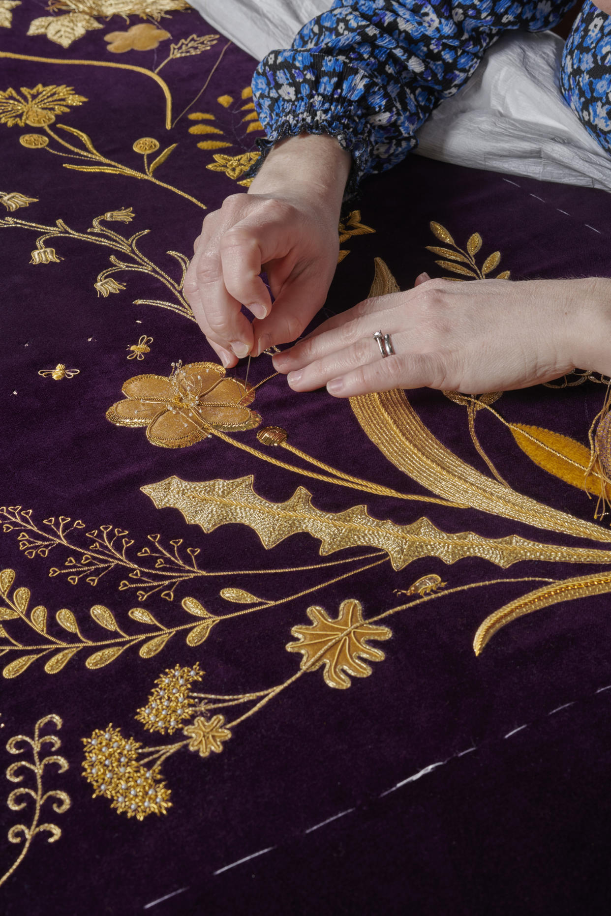 Undated handout photo issued by Buckingham Palace of a member of the Royal School of Needlework hand embroidering the Queen Consort's Robe of Estate, which she will wear at the coronation on May 6. Issue date: Saturday April 29, 2023. (Royal School of Needlework / PA Wire)