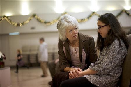 Members of the congregation at New Covenant Community Church greet Terri Roberts, the mother of Amish school shooter Charles Roberts, in Delta, Pennsylvania December 1, 2013. REUTERS/Mark Makela