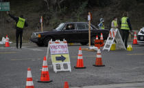 Drivers with a vaccine appointments enter a mega COVID-19 vaccination site set up in the parking lot of Dodger Stadium in Los Angeles Saturday, Jan. 30, 2021. One of the largest vaccination sites in the country was temporarily shut down Saturday because dozen of protesters blocked the entrance, stalling hundreds of motorists who had been waiting in line for hours, the Los Angeles Times reported. The Los Angeles Fire Department shut the entrance to the vaccination center at Dodger Stadium about 2 p.m. as a precaution, officials told the newspaper. (AP Photo/Damian Dovarganes)