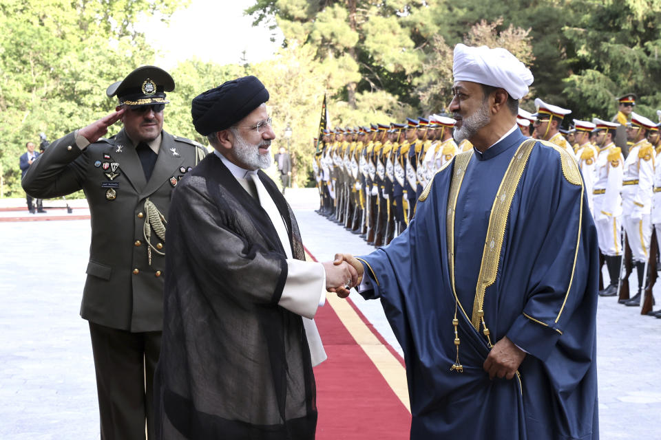 In this photo released by the office of the Iranian Presidency, Oman's Sultan Haitham bin Tariq Al Said, front right, is welcomed by Iranian President Ebrahim Raisi, front left, during an official welcoming ceremony at the Saadabad Palace in Tehran, Iran, Sunday, May 28, 2023. Oman has a long record of being a key broker between Iran and the West, amid volatile regional tensions. (Iranian Presidency Office via AP)