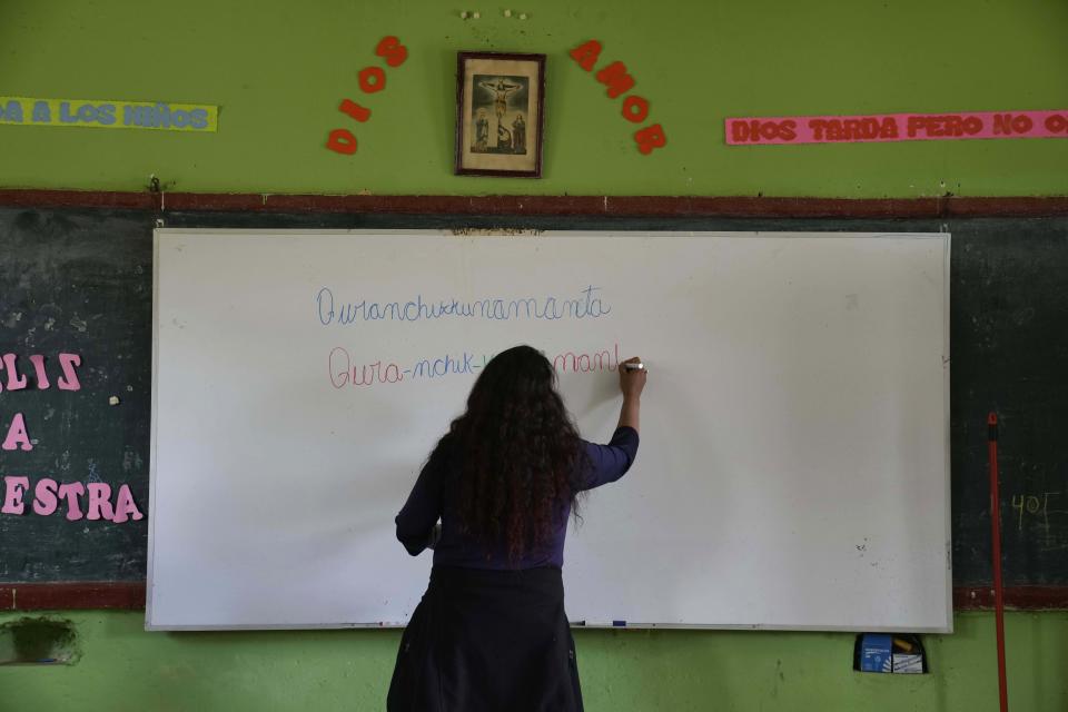 Teacher Carmen Cazorla writes in the Quechua Indigenous language during a class on medicinal plants at a public primary school in Licapa, Peru, Wednesday, Sept. 1, 2021. “For 500 years Spanish has been imposed in a way that reflects the racist and classist values of Peruvian society,” said Cazorla, an anthropologist who also teaches Quechua at the Catholic University of Peru. (AP Photo/Martin Mejia)