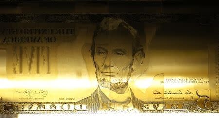 A detail of an engraving printing plate of former U.S. President Abraham Lincoln on the five-dollar bill currency are seen on a printing press at the Bureau of Engraving and Printing in Washington March 26, 2015. REUTERS/Gary Cameron