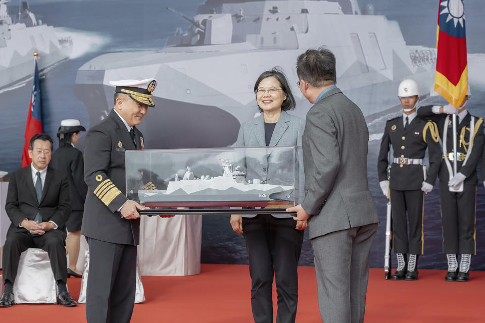 In this photo released by the Taiwan Presidential Office, Taiwan's President Tsai Ing-wen, center, receives a model showing the newly commissioned navy ships in the northern Taiwan port of Suao on Tuesday, March 26, 2024. Taiwan has commissioned two new navy ships as a safeguard against the rising threat from China, which has been ratcheting up its naval and air force missions around the island that it claims as its own territory to be annexed by force if necessary. The pair of Tuo Chiang class corvettes completes the first order of six of the domestically produced catamarans with stealth capabilities. (Taiwan Presidential Office via AP)