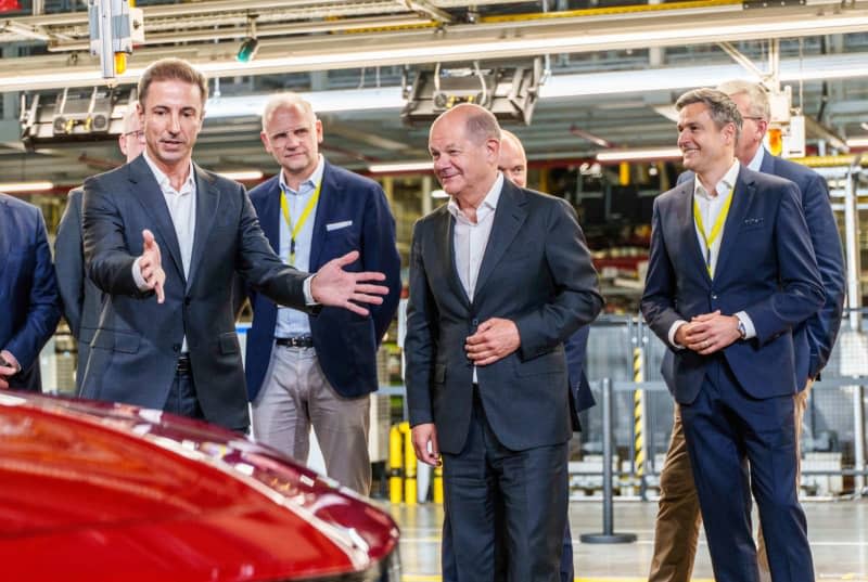 Florian Huettl (L), Managing Director of Opel Automobile GmbH, and German Chancellor Olaf Scholz (C) inspect production at a ceremony to mark 125 years of Opel vehicle production at Opel's headquarters. Opel has produced more than 75 million vehicles since 1899. Andreas Arnold/dpa