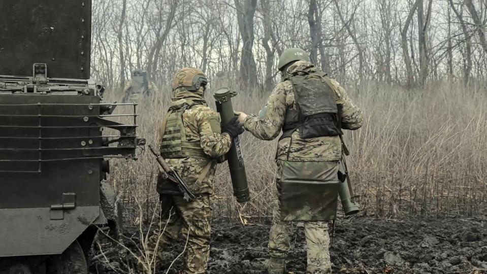 In this photo released by Russian Defense Ministry Press Service on Tuesday, April 9, 2024, Russian Army soldiers run to fire from flamethrowers toward Ukrainian positions at an undisclosed location in Ukraine. (Russian Defense Ministry Press Service via AP)