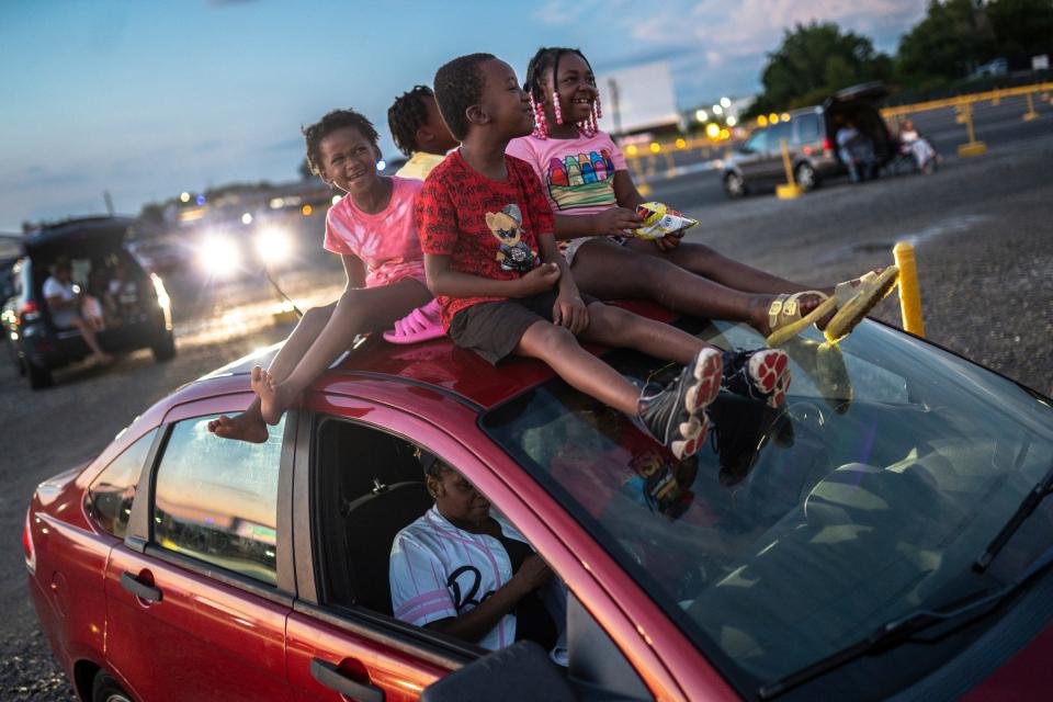 Christine Collins, of Eastpointe, left, sits on top of her family's car with her siblings Justin Collins, Christian Collins and cousin Rayne Bowen as they wait for the showing of "Bad Boys Ride or Die" at the Ford-Wyoming Drive-In in Dearborn on Tuesday, July 16, 2024.