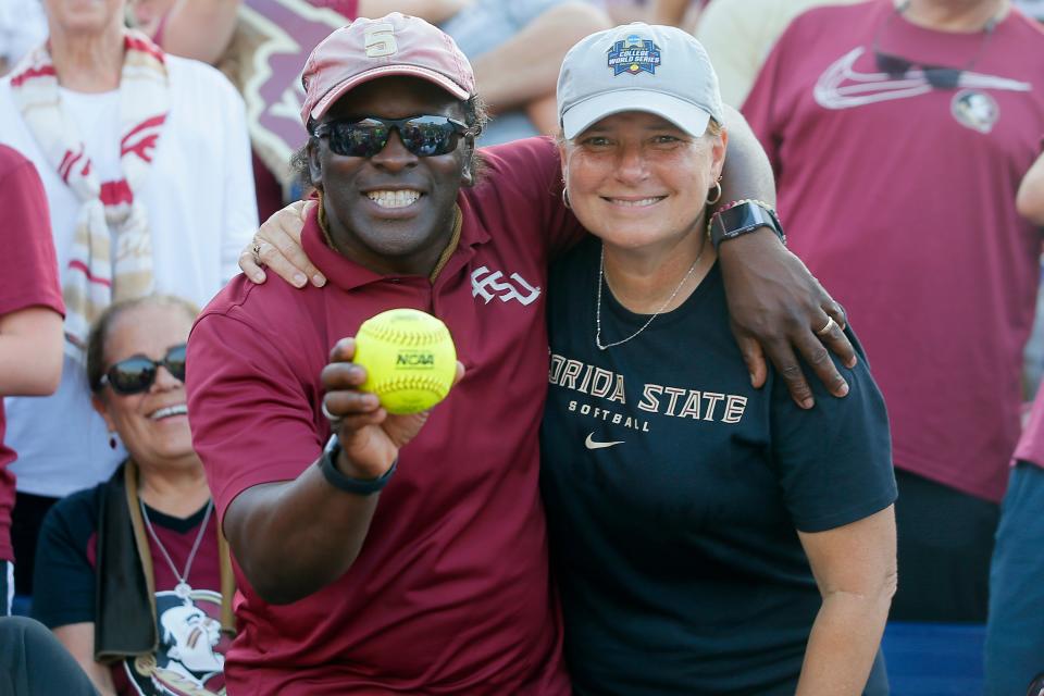 Karl and Sara Mason pose with the home run ball their daughter Elizabeth Mason hit during the second game of the Women's College World Series championship series between the University of Oklahoma Sooners (OU) and Florida State University at the USA Softball Hall of Fame Stadium in Oklahoma City, Wednesday, June 9, 2021.