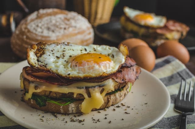 Croque madame delicious french breakfast with ham, cheese, egg and spinach with garlic