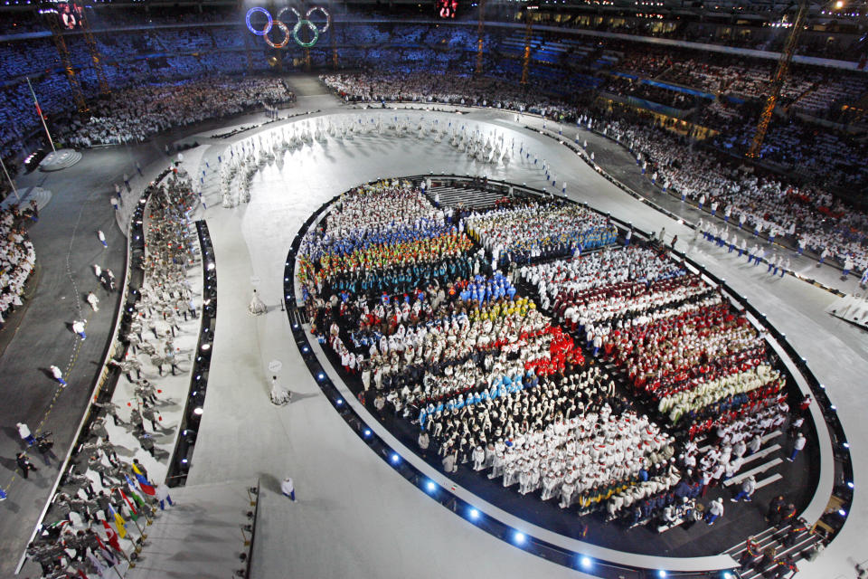 FILE - Athletes enter the stadium during the opening ceremony of the 2006 Winter Olympic Games in Turin, Italy, Friday, Feb. 10, 2006. Creative director Marco Balich, reveals to The Associated Press that he has been working for a year on a 30-minute show that will run ahead of the Soccer World Cup 2022 opening game between Qatar and Ecuador. He says local organizers "wanted to create a real show, which FIFA is not accustomed to.” (AP Photo/Kevork Djansezian, Pool, File)