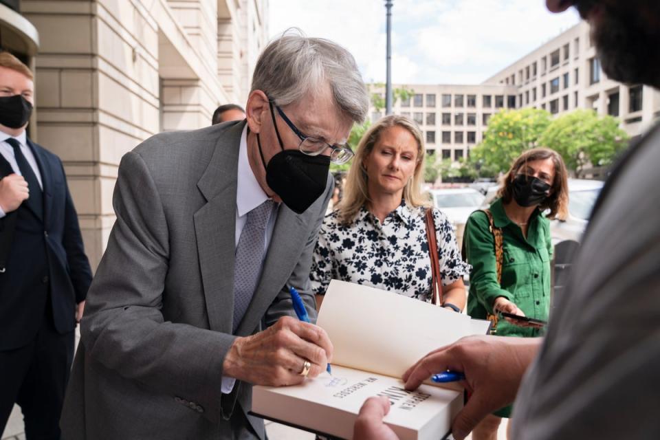 Stephen King signs autographs as he leaves court after testifying against the proposed merger of Penguin Random House and Simon & Schuster (AP)