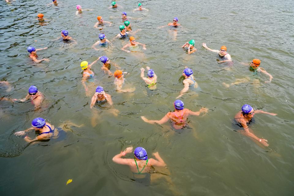 A wave of competitive female swimmers float in the water before beginning the Bill Keating, Jr. Great Ohio River Swim on Sunday, Aug. 27, 2023 in Downtown Cincinnati. The altered course, due to the current being “triple what it typically is,” according to Caroline Keating, begins at the Serpentine Wall and ends beneath the Paddlewheel monument at Public Landing in Downtown Cincinnati.