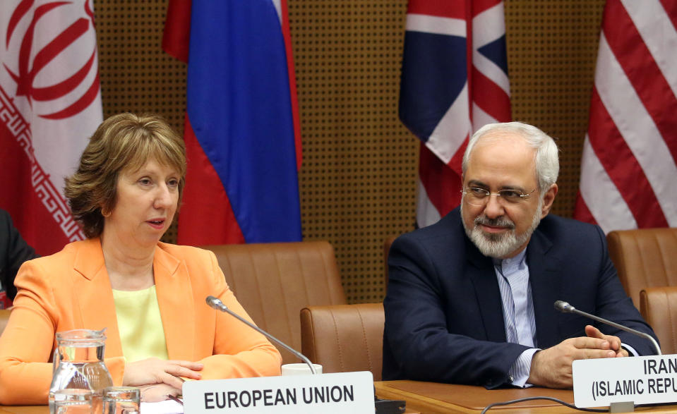 European foreign policy chief Catherine Ashton, left, and Iranian Foreign Minister Mohamad Javad Zarif, right, wait for the start of closed-door nuclear talks in Vienna, Austria, Wednesday, March 19, 2014. Iran and six world powers appear to be tackling less sensitive issues first at nuclear talks meant to curb Tehran's atomic activities in exchange for full sanctions relief. Iran's official IRNA news agency says Wednesday's talks are focusing on a heavy water reactor. The six want the nearly finished reactor shut down, or converted to a type that produces less plutonium, a material that could be used to make nuclear weapons. (AP Photo/Ronald Zak)