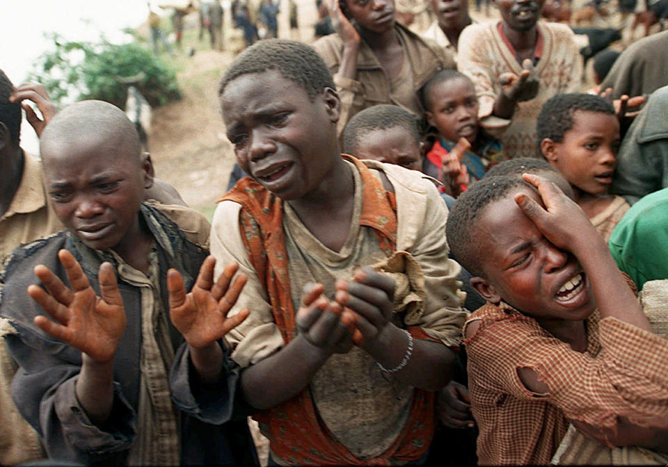 FILE - Rwandan refugee children plead with Zairean soldiers to allow them across a bridge separating Rwanda and Zaire where their mothers had crossed moments earlier before the soldiers closed the border, in Zaire, now known as Congo, Aug. 20, 1994. (AP Photo/Jean-Marc Bouju, File)
