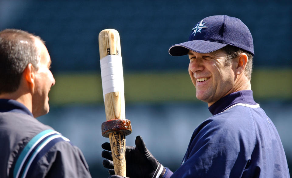 FILE - In this April 5, 2004, file photo, Seattle Mariners designated hitter Edgar Martinez, right, chats with trainer Rick Griffin during practice in Seattle. Martinez trained for every aspect of his career. As a player he spent nearly two decades doing daily eye exercises to overcome strabismus, a condition that prevented his eyes from seeing in tandem. Rather than letting that become the excuse that kept him out of baseball, Martinez became arguably the best right-handed hitter of his generation and the prototype for what a designated hitter can be. (AP Photo/Elaine Thompson, File)