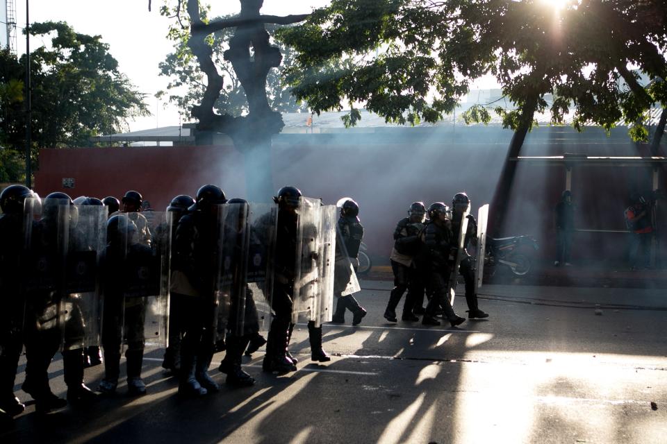 Bolivarian National Police advance toward opposition demonstrators in Caracas, Venezuela, Saturday, Feb. 15, 2014. Venezuelan security forces backed by water tanks and tear gas are dispersing groups of anti-government demonstrators who blocked Caracas' main highway Saturday evening. (AP Photo/Alejandro Cegarra)