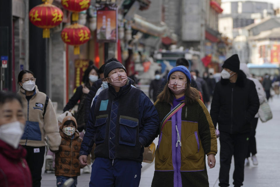 Visitors wearing face masks tour a pedestrian shopping street at Qianmen walking street in Beijing, Tuesday, Jan. 3, 2023. As the virus continues to rip through China, global organizations and governments have called on the country start sharing data while others have criticized its current numbers as meaningless. (AP Photo/Andy Wong)