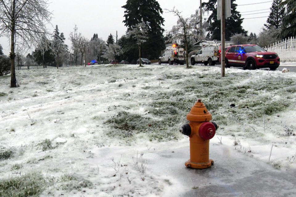 In this image made from a video provided by KGW, authorities work the scene Wednesday, Jan. 17, 2024, in Portland, Ore, after a power line fell on a vehicle, killing three people and injuring a baby during an ice storm that turned roads and mountain highways treacherous in the Pacific Northwest. (KGW via AP)